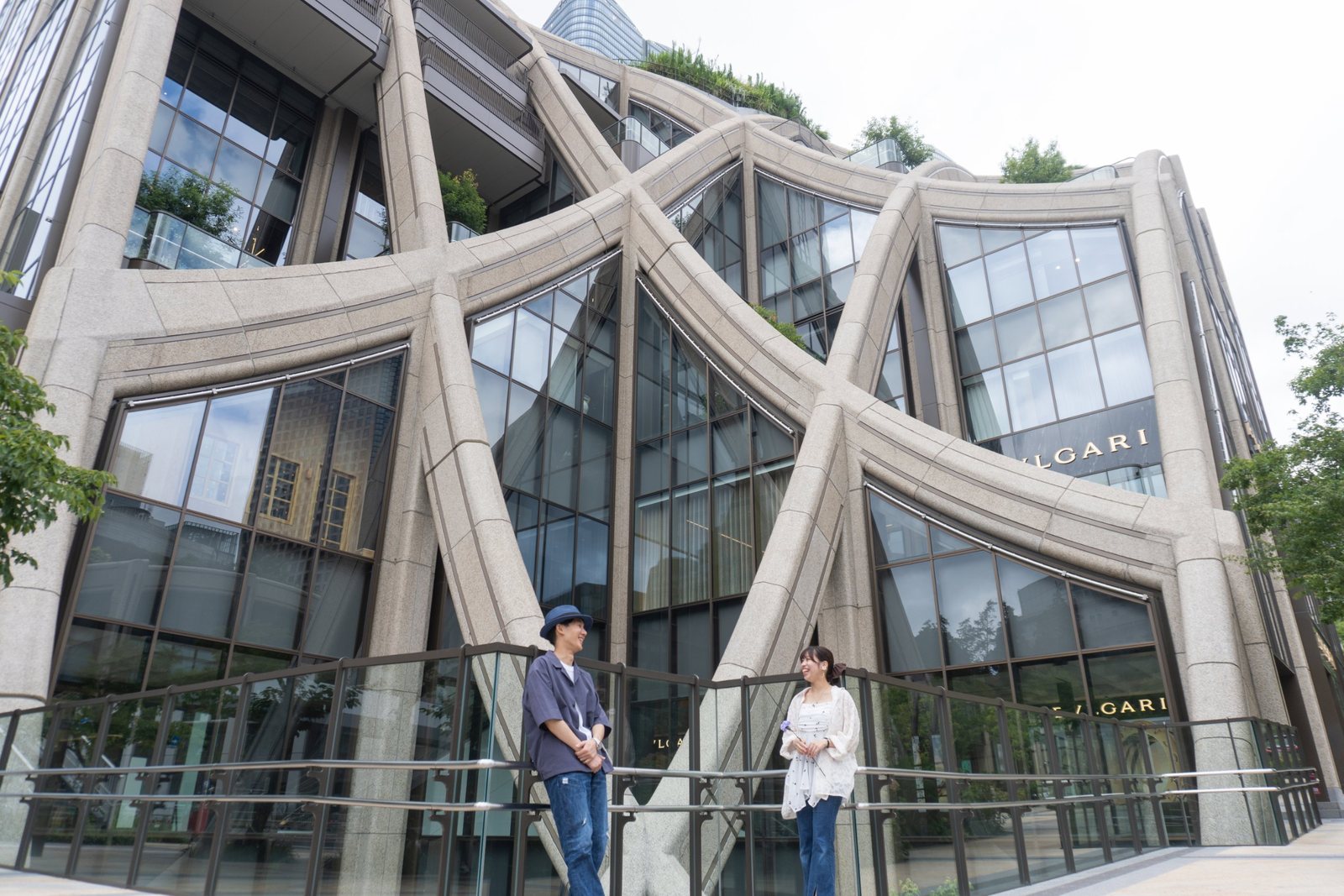 大きな建物の前で、向かい合って笑い合うカップル