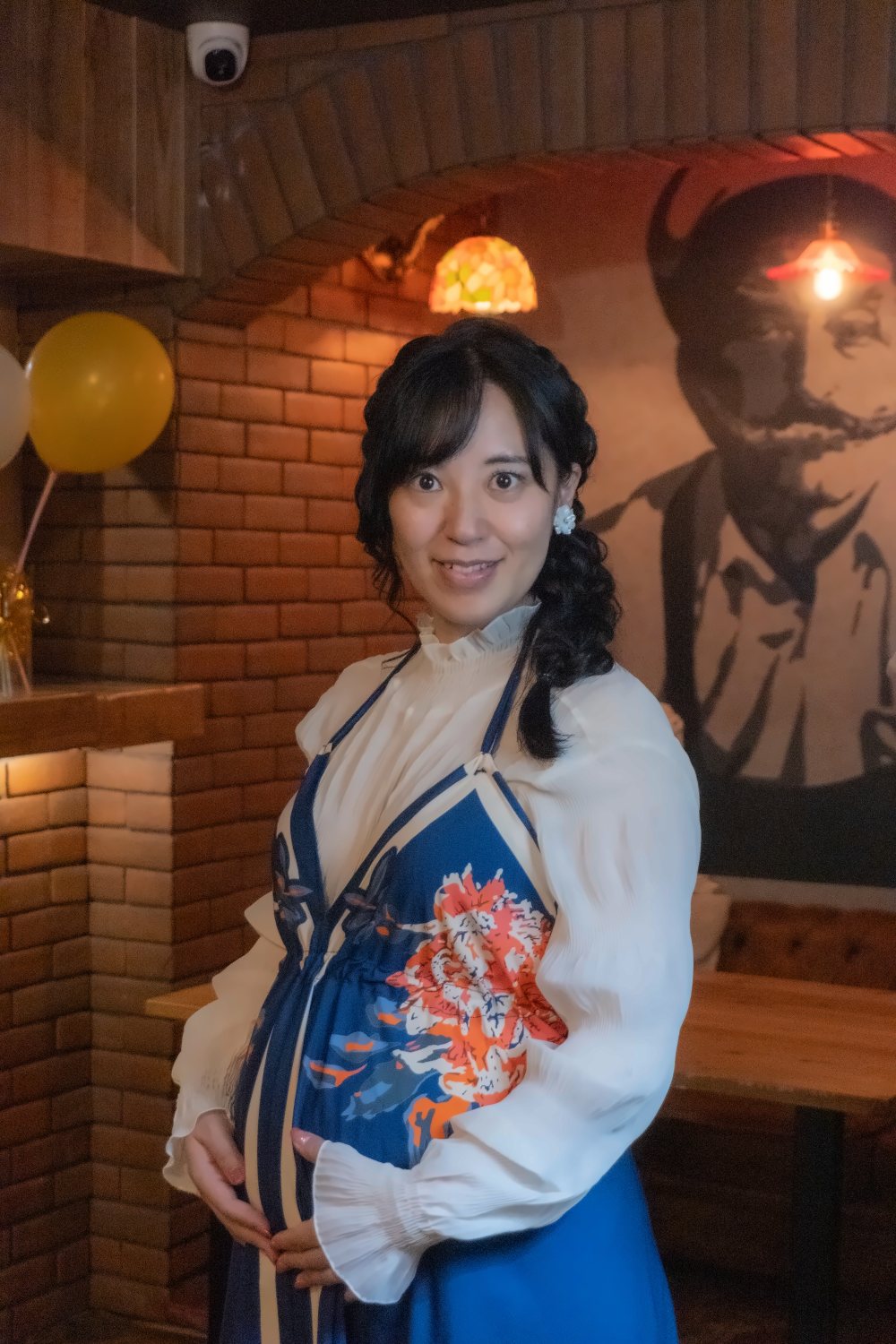 バーで撮影した、おなかに手を添えて微笑む妊婦さんの写真